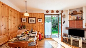 Ein Essbereich mit Holzwänden, einem gedeckten Tisch mit Tellern, Gläsern und einem Blumenstrauß.