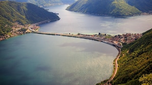 Eine Küstenstadt mit Brücke, Bergen und einem großen Gewässer.