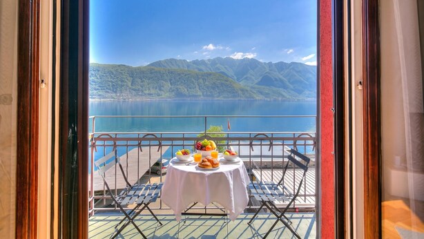 Una mesa con alimentos para el desayuno y vistas a un lago y montañas.