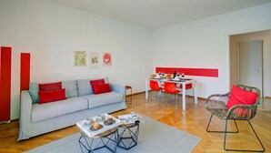 Una sala de estar moderna con sofá, mesa de comedor y sillas.