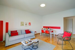 Ein modernes Wohnzimmer mit einer Couch, einem Esstisch und Stühlen.