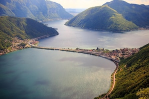Eine Küstenstadt mit Brücke, Bergen und einem großen Gewässer.