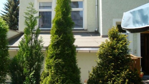Ein Gebäude mit mehreren Fenstern, einer Tür und einem überdachten Außenbereich.