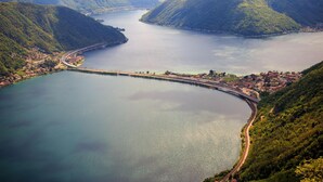 Une ville côtière avec un pont, des montagnes et une vaste étendue d’eau.