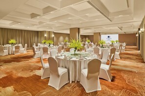 A conference room with round tables, white chairs, and floral centerpieces. - Doubletree by Hilton Changsha Tianxin (Changsha)