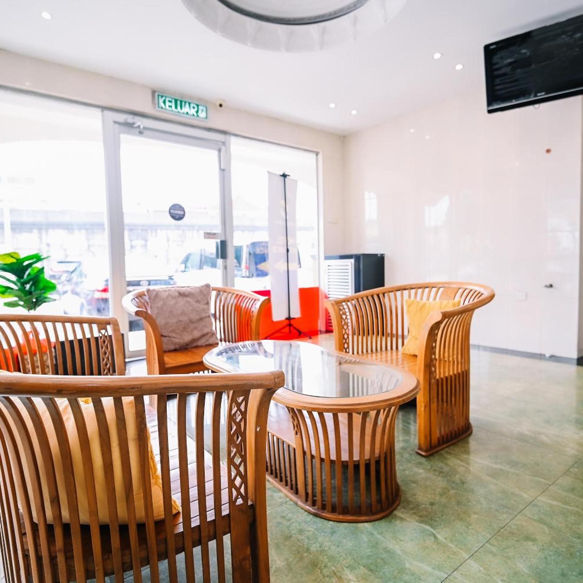A modern interior with wicker furniture, a glass table, and a view through a glass door.
