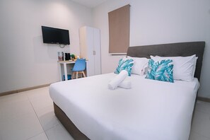 A hotel room with a bed, a desk, a chair, a television, and a wardrobe. - Swing & Pillows @ Sunway Pyramid PJ (Petaling Jaya)