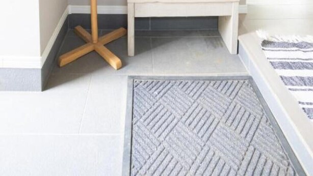 A corner room with a wooden coat rack, a small bench, and a herringbone-patterned rug. - GREY HOUSE NISEKO (Niseko)
