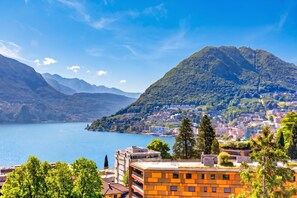 A mountainous landscape with a lake, buildings, and trees. - Lugano Sun & View Apartment for 4, Lugano, Switzerland (Lugano)