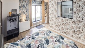 A bedroom with a bed, a dresser, a mirror, and a window with curtains. - Charmante maison avec piscine (Cierzac)