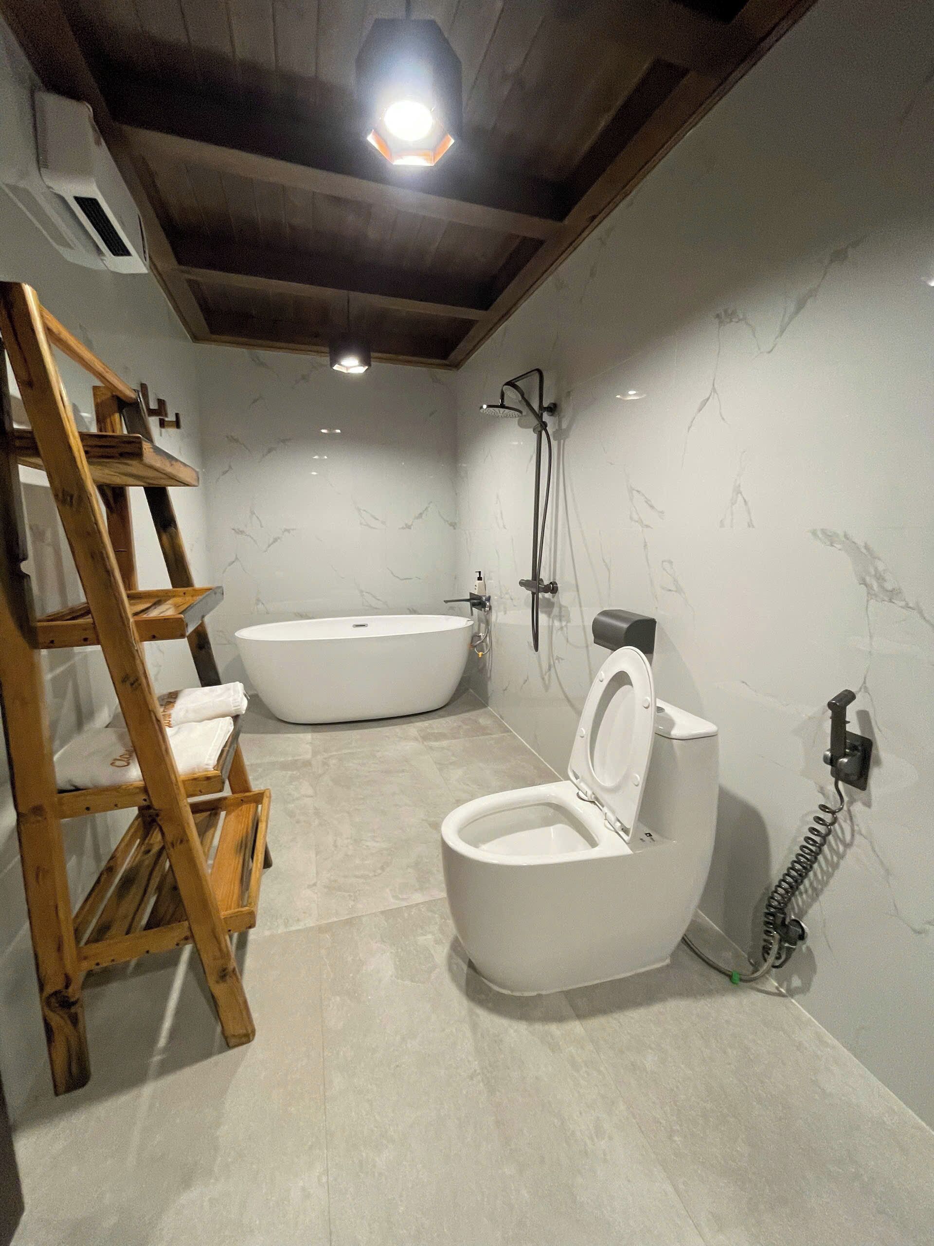 Bañera con ducha, pantuflas, jabón, shampoo
