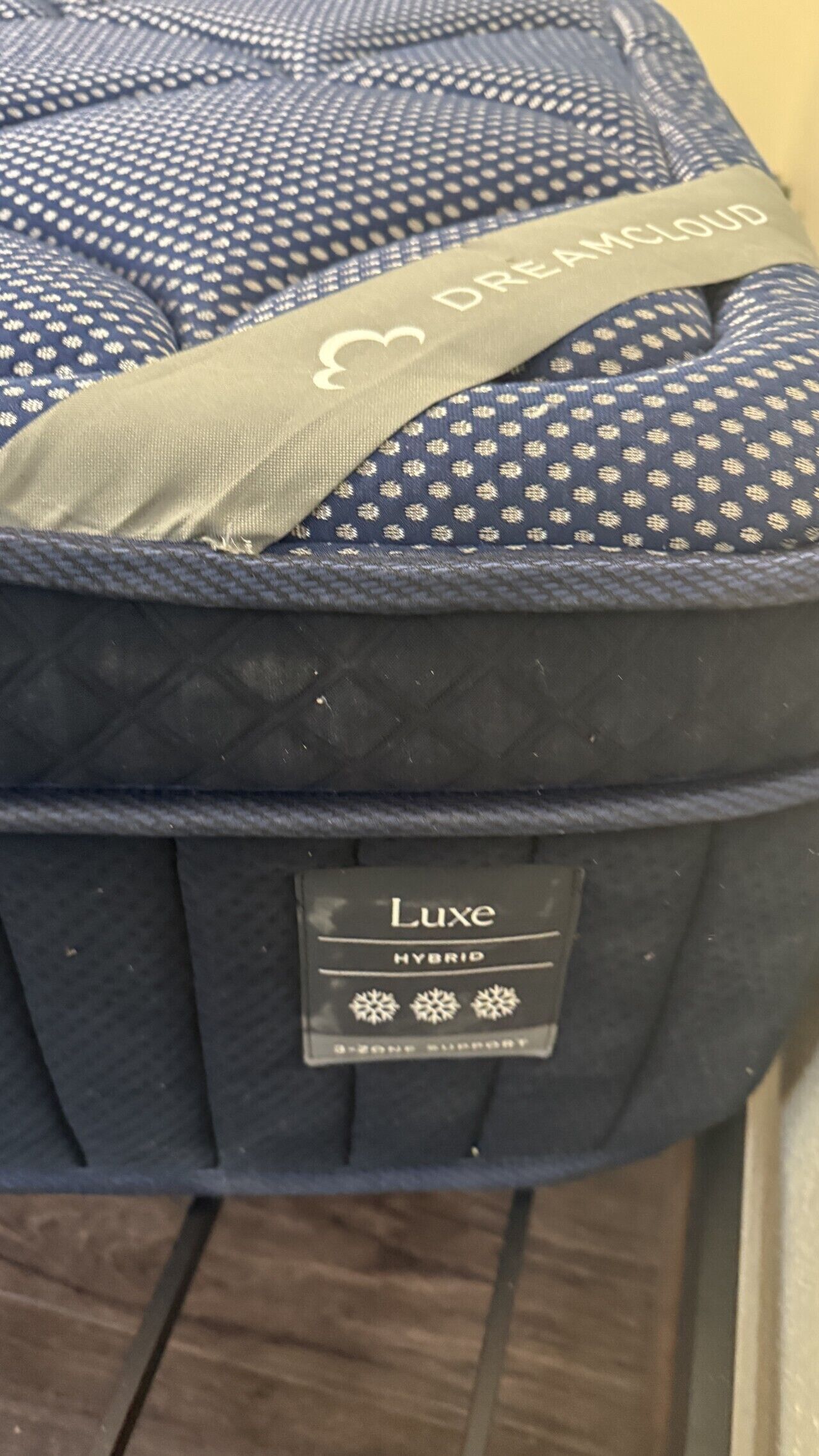 A Luxe Hybrid suitcase with a quilted pattern and a grey shoulder strap.