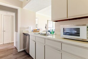 A kitchen with a dishwasher, a sink, and a microwave.