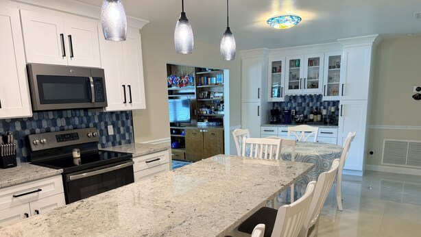 A kitchen with granite countertops, white cabinetry, stainless steel appliances, and pendant lighting. - Family-Friendly 2-bedroom 2-bath house close to Tampa Airport (Tampa)