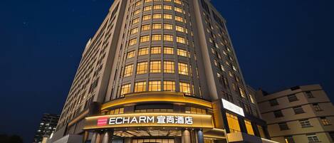 A high-rise hotel with a prominent entrance, multiple floors, and illuminated windows.