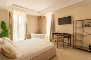 Een hotelkamer met een bed, een bureau, een stoel, een televisie en een kledingkast.