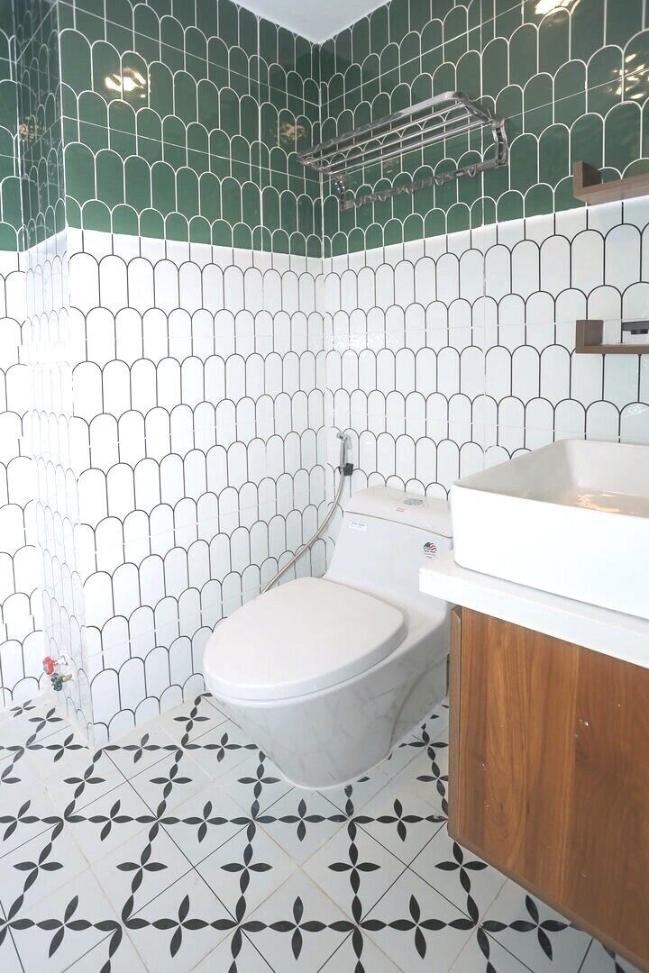 A bathroom with a toilet, a sink, and a shower area.