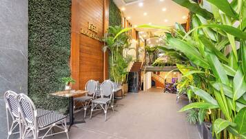 Recepció d'hotel amb paret de fusta, escala i plantes d'interior.