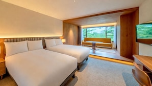 A hotel room with a large bed, bedside tables, a desk, and a window with a view of greenery. - UNWIND HOTEL & BAR OKUNIKKO (Nikko)
