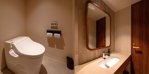 Een aparte badkuip en douche, een haardroger, handdoeken, toiletpapier