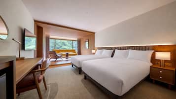 Una habitación de hotel con una cama grande, un escritorio, una silla y vistas al exterior.