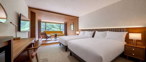 A hotel room with a large bed, a desk, a chair, and a view of the outdoors.