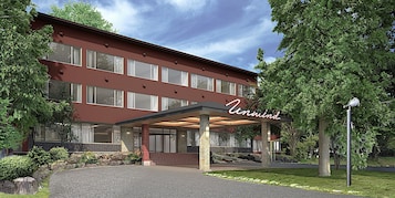 A hotel with a red facade, large windows, and a covered entrance area.
