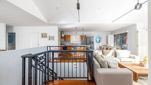 Ein modernes Interieur mit einer Treppe, einer Essecke und einer Küche.