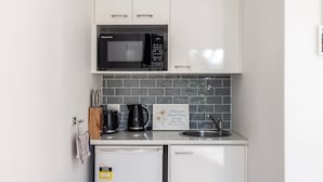 A compact kitchenette with a microwave, coffee maker, and a small refrigerator. - Studio Retreat on  Flannel Flower Shoal Bay (Shoal Bay)