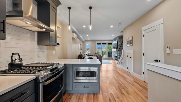 A modern kitchen with a stove, oven, microwave, and island. - Wanderlust - New 2026 Ski Townhome - Walk to Town Square - Game Loft & Bar (Waterville Valley)