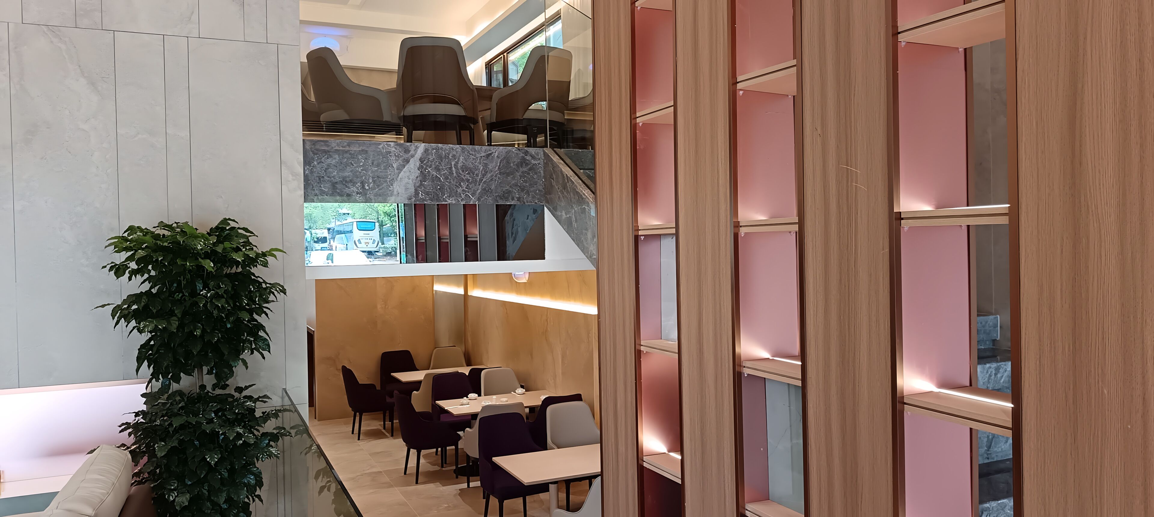 A multi-level interior with seating areas, a staircase, and a view of the outside.