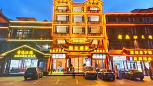 Un hotel de estilo arquitectónico tradicional, con varios pisos y señalización iluminada.