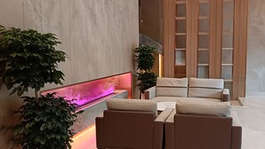 Un área de descanso moderna con un sofá, un televisor de pantalla plana y plantas decorativas.