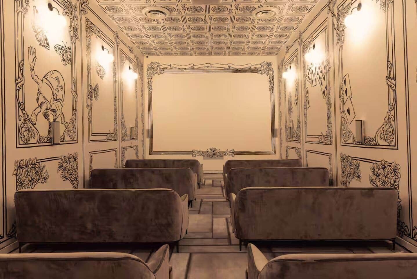 Un teatro con asientos de terciopelo, decoraciones de pared ornamentadas y un techo con diseño.