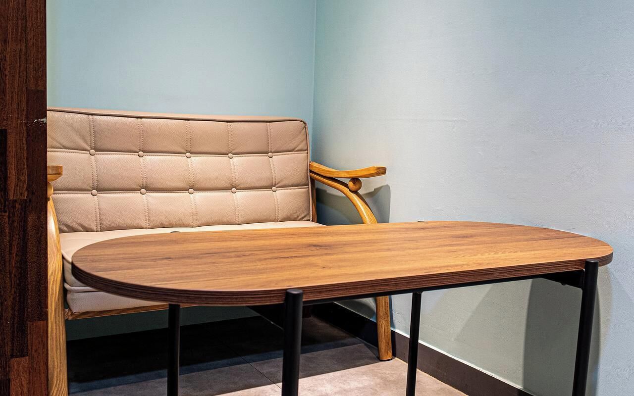 A corner seating area with a cushioned bench and a wooden table.