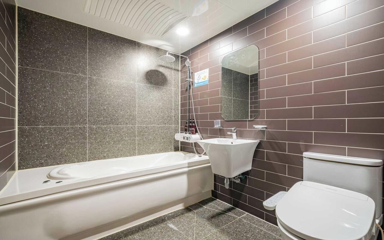 Ein modernes Badezimmer mit Badewanne, Waschbecken und Toilette.