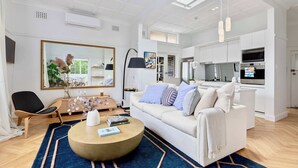 Uma sala de estar moderna com sofá, mesa de centro e área de jantar com cozinha.