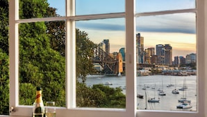 Uma janela com vista para a paisagem urbana, incluindo uma ponte e edifícios.