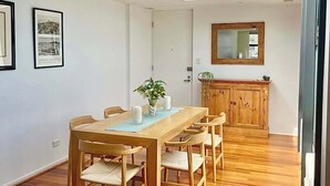 Ein moderner Essbereich mit Holztisch und -stühlen, einer Glaskuppel und einem Holzschrank.