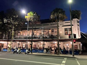 Ein zweistöckiges Gebäude mit Restaurant im Erdgeschoss, inklusive Außenbereich und gut erkennbarem Eingang.