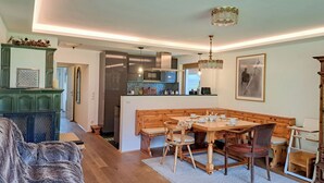Una sala de estar acogedora con chimenea, un comedor con mesa y sillas de madera, y una cocina con electrodomésticos modernos.