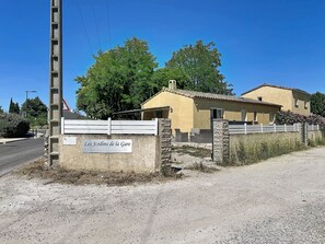 A property named 'Les Jardins de la Gare' with a gravel driveway, a white fence, and a yellow building with a tiled roof. - Villa des Amoureux by Interhome (Saint-Geniès-de-Malgoirès)