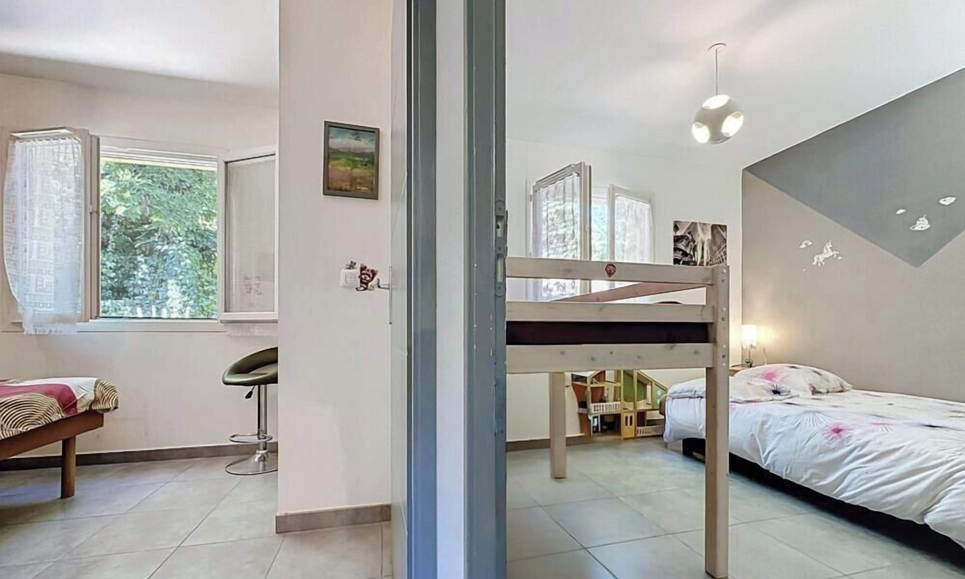 A room with bunk beds, a desk, and a chair.