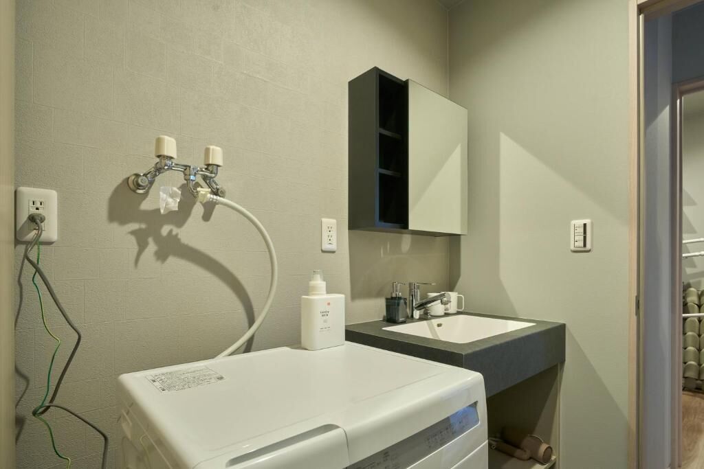 A bathroom with a white sink, a mirror above it, and a towel rack.