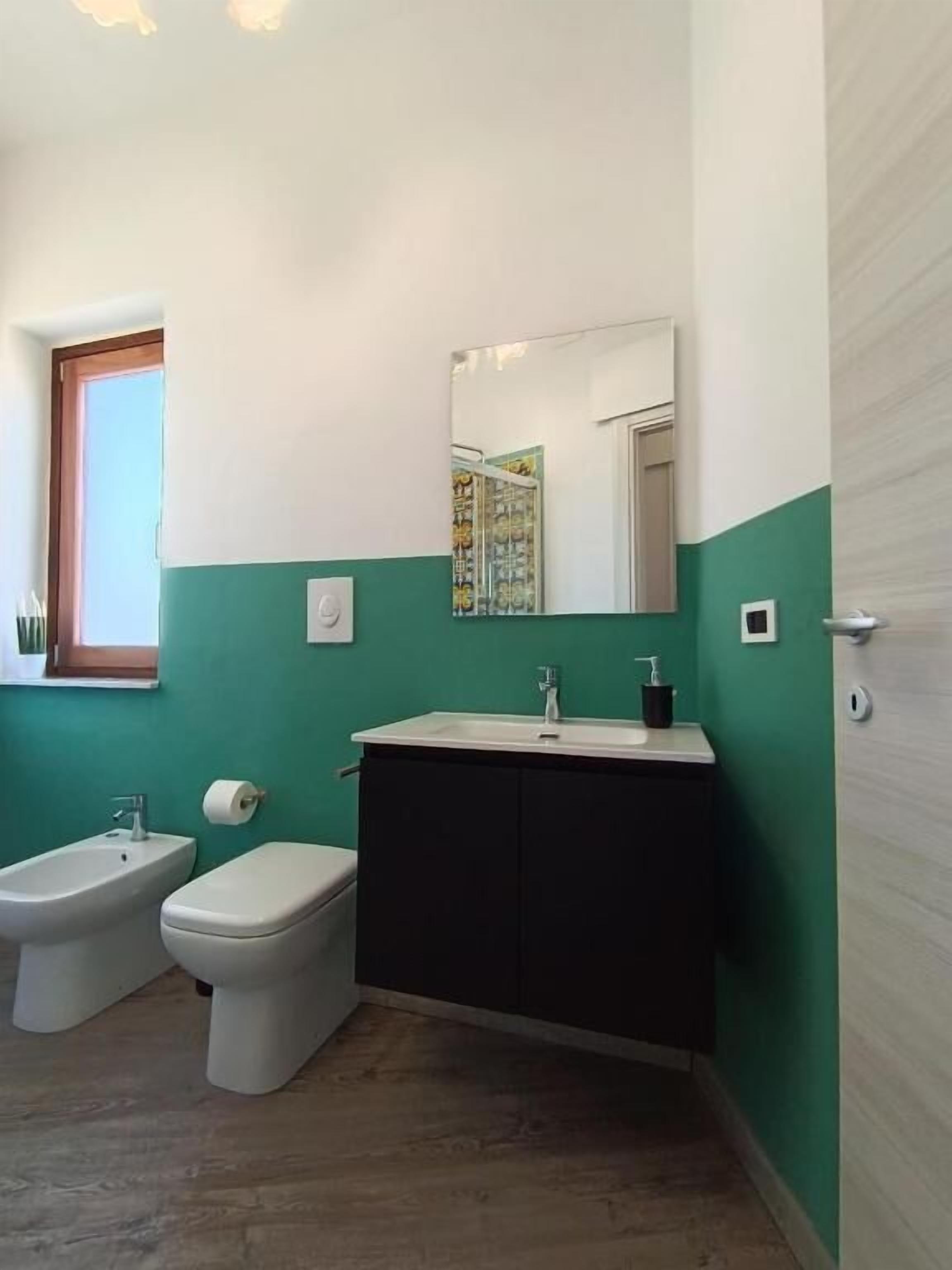 A bathroom with a toilet, bidet, and sink.
