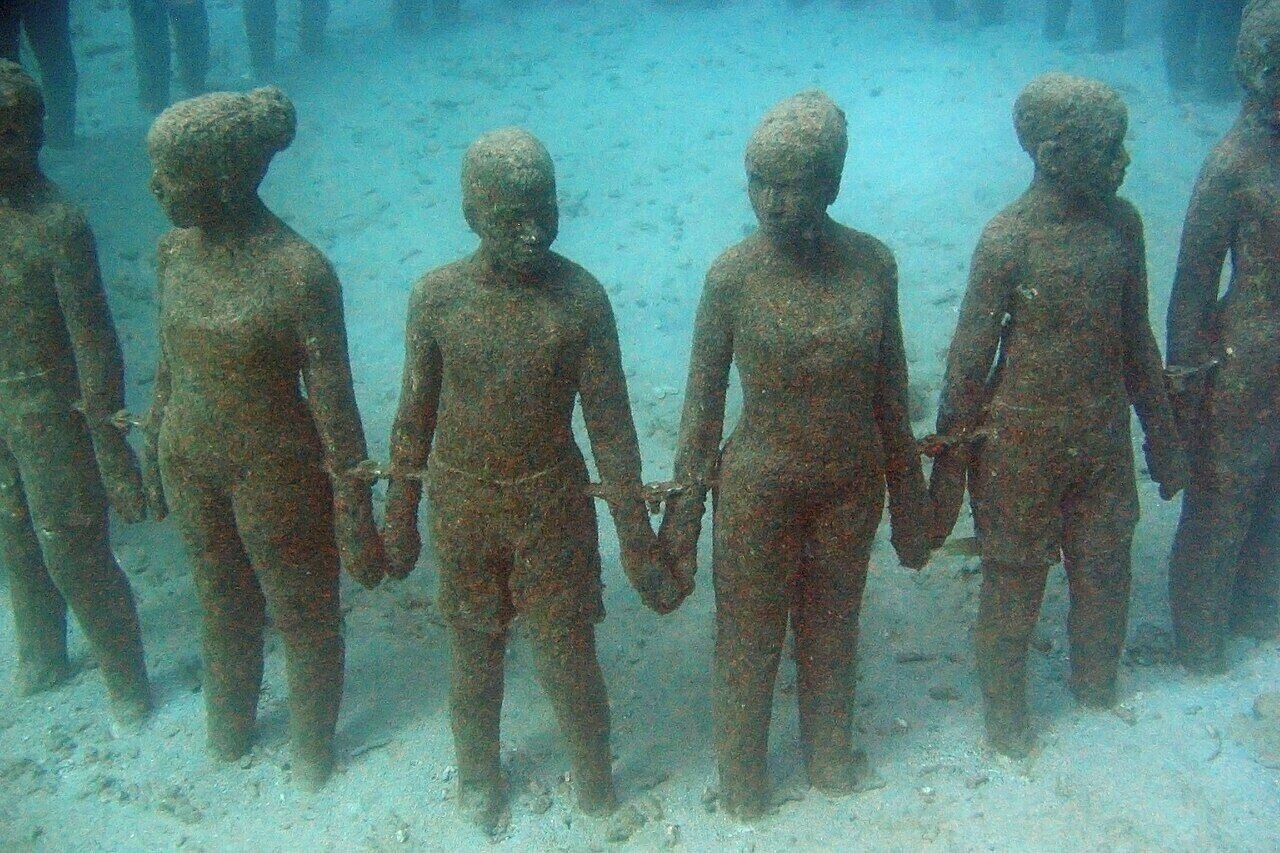 Onderwaterbeelden van menselijke figuren die de handen schudden.