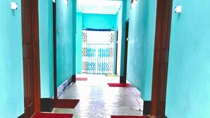 A long hallway with teal walls, wooden flooring, and red carpets. - Tenzin Homestay — Cozy Stay with Free Wi-Fi, Parking & Mountain Views in Dirang (Dirang)