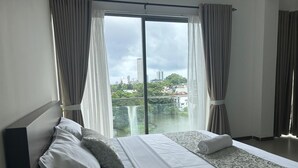 Une chambre d’hôtel avec un grand lit, une vue sur la ville et un balcon.