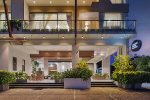 Entrada de hotel con mostrador de recepción, zona de estar y cartel que indica 'Water Park Suites'.