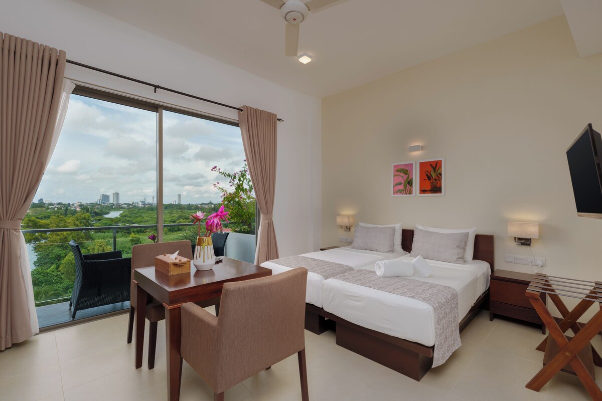 Una habitación de hotel con una cama grande, un escritorio, una silla y vistas a la ciudad.